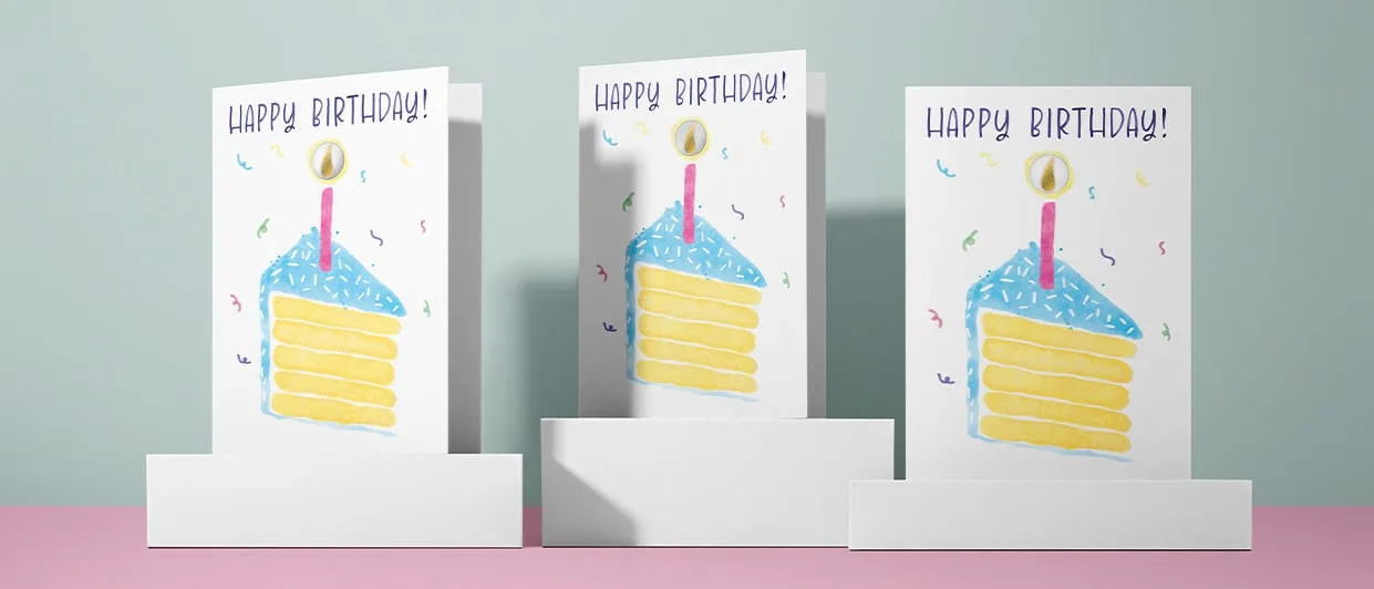 Three birthday cake cards displayed on white plinths against a sage backdrop